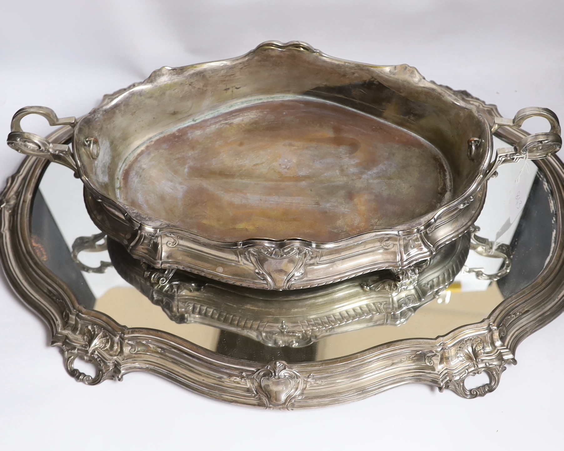 A large ornate Belgian? 800 standard white metal two handled oval centrepiece, 53cm, 46.1oz, with a base metal liner, on a similar 800 standard white metal mounted mirrored stand, 70cm.